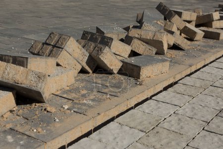 Foto de In the process of building a street sidewalk where a pile of stacked laying bricks - Imagen libre de derechos