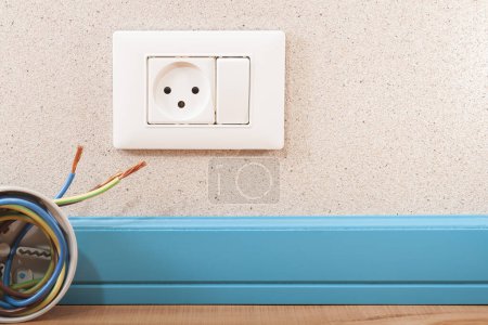 Foto de Toma eléctrica con interruptor en la pared y junto a una caja de conexiones con cables - Imagen libre de derechos