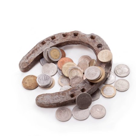Foto de Real herradura vieja y monedas de diferentes países sobre un fondo blanco - Imagen libre de derechos