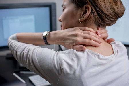 Photo for Tired woman massaging rubbing stiff sore neck tensed muscles fatigued from computer work in incorrect posture feeling hurt joint shoulder back pain ache. - Royalty Free Image