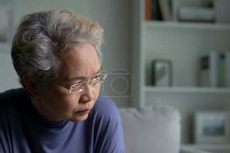 Foto de Retrato de mujer mayor asiática triste y solitaria en sala de estar - Imagen libre de derechos