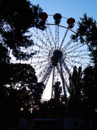 Big and high panoramic observation wheel in the evening in an urban city park in Kyiv, Ukraine.