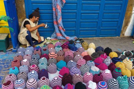 Foto de Marruecos. Essaouira. Un vendedor de sombreros de lana prepara su té de menta - Imagen libre de derechos