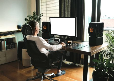 Téléchargez les photos : Homme d'âge moyen travaillant sur ordinateur à la maison, maquette d'écran blanc. - en image libre de droit