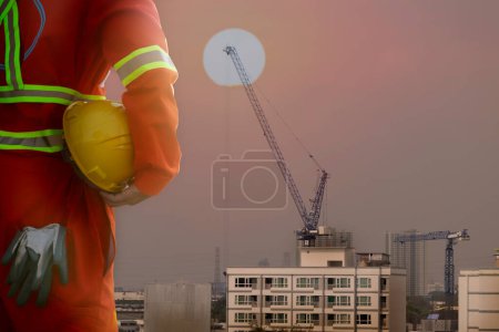 Téléchargez les photos : Ingénieur tenant casque sur le fond du chantier de construction - en image libre de droit