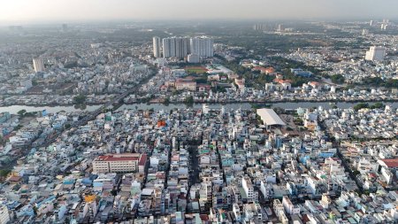 Foto de Increíble vista aérea de la gran ciudad asiática, escena Ho Chi Minh, concurrida casa adosada junto al río con densidad densa, superpoblada urbana, calle Nguyen Tri Phuong con puente que cruza el canal Tau Hu - Imagen libre de derechos