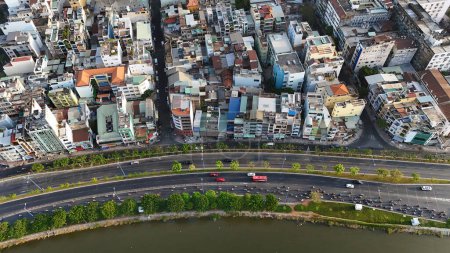 Erstaunliche Luftaufnahme per Drohne von Ho-Chi-Minh, große asiatische Stadt mit überfülltem Stadthaus, Fahrzeug bewegt sich auf der Straße bis zur Kreuzung, Haus dicht an Wohngebiet, Stadtbild Skyline am Abend