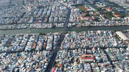 Increíble vista aérea de la gran ciudad asiática, escena Ho Chi Minh, concurrida casa adosada junto al río con densidad densa, superpoblada urbana, calle Nguyen Tri Phuong con puente que cruza el canal Tau Hu