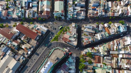 Amazing aerial view by drone of Ho Chi Minh, big Asian city with crowded townhouse, vehicle circulate on street move to intersection, house close together of residence area, cityscape skyline at evening