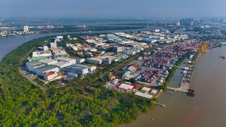 Vista aérea desde el dron del puerto de la ciudad de Ho Chi Minh, sistema de canales para la vía navegable del tráfico en el río Saigón, grúa y contenedor en el puerto junto al río, logística para la exportación, importación industrial con gastos baratos
