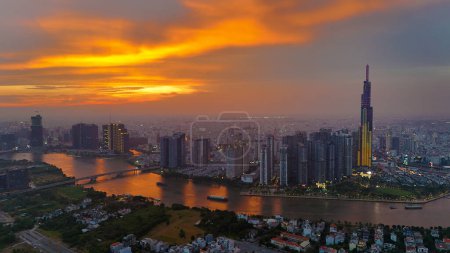 Ho Chi Minh city, Viet Nam, March 29, 2024: Aerial view of Asia city at sunset by drone with Landmark 81 skycraper modern building, boat on Saigon river, night skyline of Vietnam