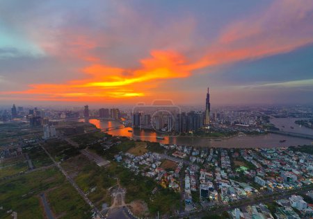 Foto de Ho Chi Minh city, Viet Nam, 29 de marzo de 2024: Vista aérea de la ciudad de Asia al atardecer con un dron con un edificio moderno de rascacielos Landmark 81, barco en el río Saigón, horizonte nocturno de Vietnam - Imagen libre de derechos