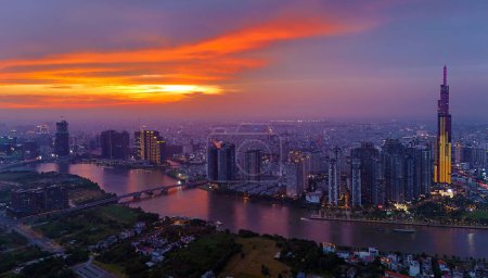 Foto de Ho Chi Minh city, Viet Nam, 29 de marzo de 2024: Vista aérea de la ciudad de Asia al atardecer con un dron con un edificio moderno de rascacielos Landmark 81, barco en el río Saigón, horizonte nocturno de Vietnam - Imagen libre de derechos