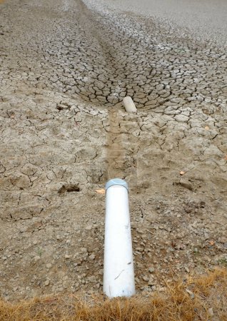 Dried soil surface, waterless sewer pipes after long time hot season at Mekong Delta, Viet Nam, climate change and el nino make hard weather of global, drought field affect to food Securit