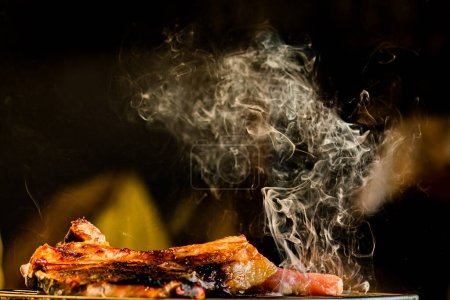 Téléchargez les photos : Fumée de steak de porc sur barbecue - en image libre de droit