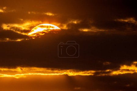Téléchargez les photos : Coucher de soleil se cacher derrière les nuages pendant le coucher du soleil doré - en image libre de droit