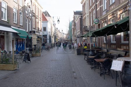 Foto de Nijmegen, Netherlands - February 10, 2023: Lange Hezelstraat with people shopping in the center of Nijmegen - Imagen libre de derechos