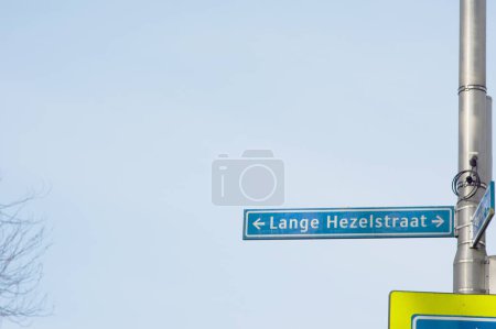 Foto de Signo de nombre de calle azul de Lange Hezelstraat con un cielo azul claro en el fondo en Nijmegen en los Países Bajos - Imagen libre de derechos