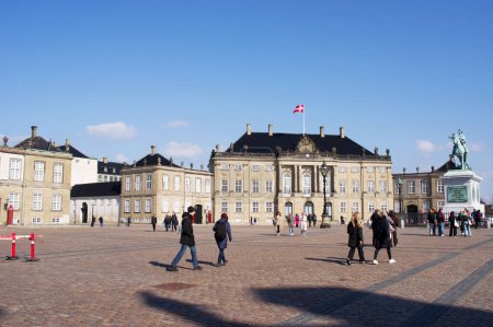 Foto de Copenhague, Dinamarca - 6 de abril de 2023: Plaza de Amalienborg con muchos turistas en el centro de Copenhague en Dinamarca con un cielo azul claro - Imagen libre de derechos