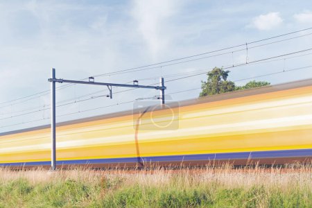 Téléchargez les photos : Le train interurbain passe à grande vitesse, flou par le mouvement à Arnhem aux Pays-Bas - en image libre de droit