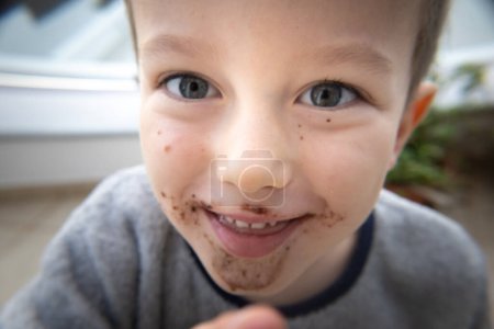 Foto de Primer plano retrato de niño elemental lindo despreocupado con la boca desordenada sonriendo al aire libre - Imagen libre de derechos