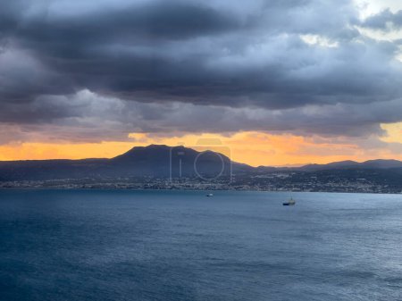Foto de Vista idílica del paisaje marino y la silueta de la cordillera contra el cielo nublado durante la puesta del sol - Imagen libre de derechos