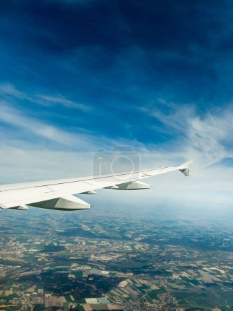 Foto de Imagen recortada del avión volando contra el cielo azul sobre la vista panorámica del paisaje en el día soleado - Imagen libre de derechos
