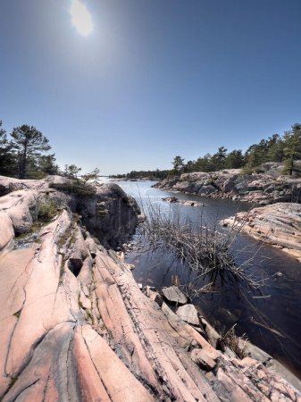 Foto de Vista panorámica del río en medio de formaciones rocosas contra el cielo azul claro en el bosque durante la temporada de verano - Imagen libre de derechos