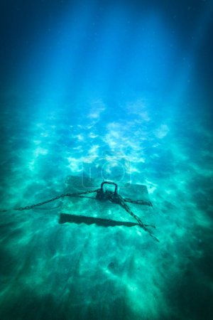 Téléchargez les photos : Vue grand angle des chaînes attachées au crochet sur bloc de béton au-dessus du plancher océanique sous la mer bleue - en image libre de droit