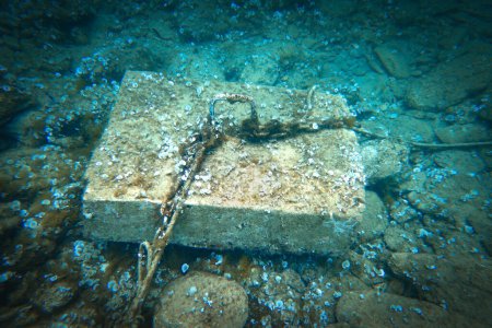 Foto de Vista de ángulo alto de la cuerda y la cadena atada al gancho en bloque de hormigón sobre el fondo del océano bajo el mar azul - Imagen libre de derechos