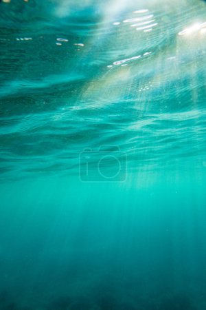 Foto de Rayos de sol que fluyen en el idílico paisaje marino azul profundo durante el día soleado - Imagen libre de derechos