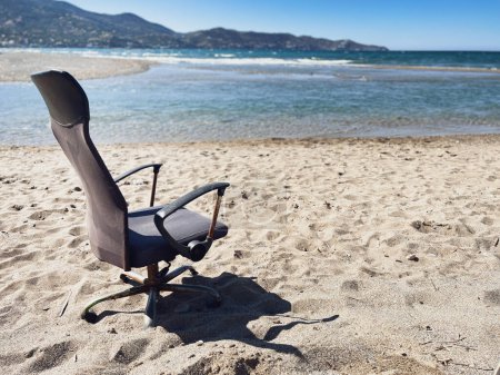 Foto de Sillón vacío abandonado en la playa de arena contra el paisaje marino y el cielo azul claro en un día soleado - Imagen libre de derechos