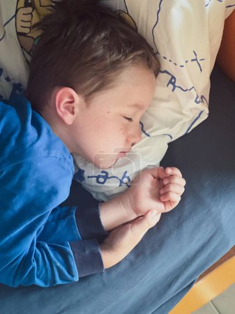 Foto de Vista de ángulo alto de lindo chico caucásico durmiendo cómodamente en la almohada y la cama en casa - Imagen libre de derechos