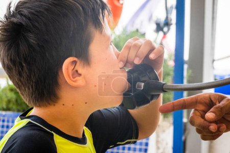Foto de Primer plano del niño usando aqualung presionando la nariz y aprendiendo buceo mientras disfruta de las vacaciones en el complejo turístico - Imagen libre de derechos
