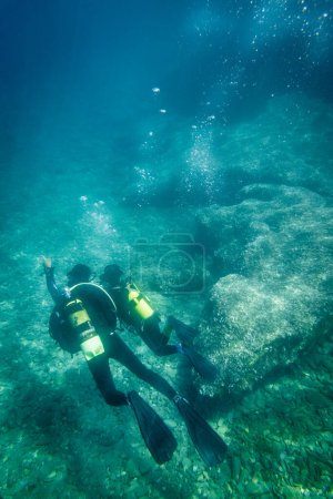 Foto de Caucásico padre y adolescente hijo buceo y explorar juntos bajo aguas profundas en el mar durante las vacaciones - Imagen libre de derechos
