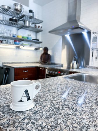 Foto de Primer plano de la letra A en taza de café blanco está en la isla de la cocina en casa - Imagen libre de derechos