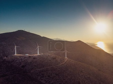 Foto de Turbinas eólicas en la cordillera y vista panorámica del majestuoso paisaje contra el sol en el cielo al atardecer - Imagen libre de derechos