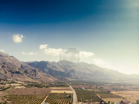Foto de Vista aérea y tranquila del paisaje de mosaico y majestuosas cadenas montañosas contra el cielo azul durante el día soleado - Imagen libre de derechos