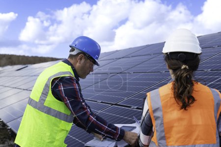 Foto de Ingeniero en panel solar y panel solar trabajando en planta de energía. - Imagen libre de derechos