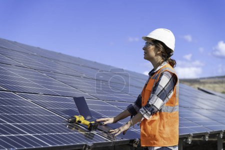 Foto de Ingeniero joven inspeccionar la instalación de paneles solares instalado comprobar con plano en el campo, con la grabación de datos de inspección en la PC. - Imagen libre de derechos