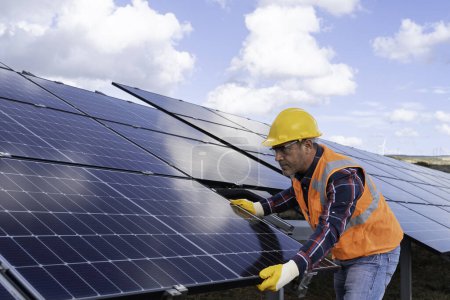 Téléchargez les photos : Homme avec l'installation de panneaux solaires font sur l'usine de panneau solaire. - en image libre de droit