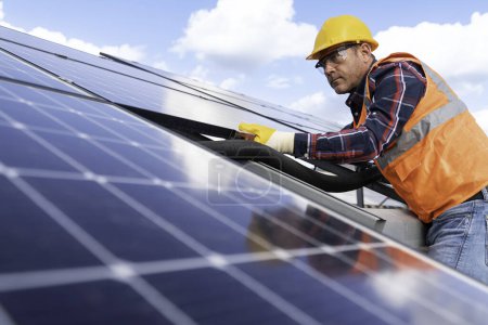 Téléchargez les photos : Homme avec l'installation de panneaux solaires font sur l'usine de panneau solaire. - en image libre de droit