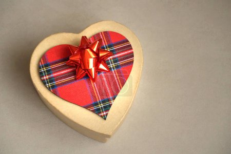 Foto de Gift box with decorative red bow and red tartan Scottish pattern heart - Imagen libre de derechos