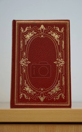 Page couverture du livre vintage rouge avec des roses dorées à l'ancienne et des détails de vrilles