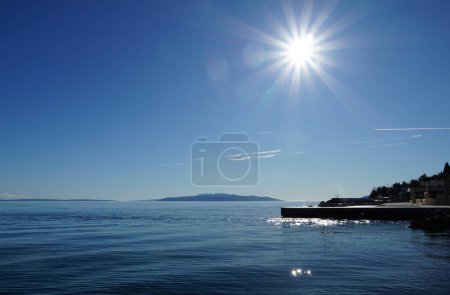 Foto de Reflejos de los rayos del sol sobre el mar azul y la ciudad frente al mar - Imagen libre de derechos
