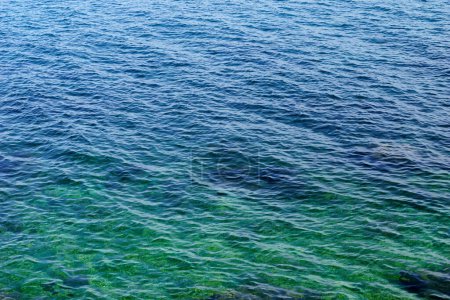 Vista aérea de la superficie ondulada del mar de color turquesa y azul