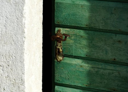 Foto de Puerta de madera vieja medio abierta con un pomo de puerta marrón vintage oxidado - Imagen libre de derechos