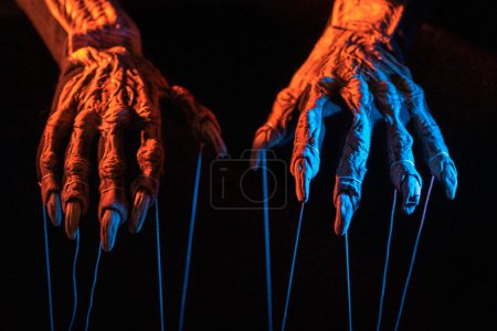 Photo for Metaphorical paws of the devil with threads for control - Royalty Free Image