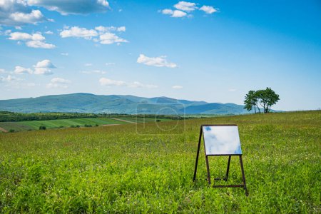 Spring landscape of the Carpathian mountains with a mirror on an easel