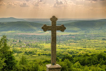 Landschaft mit einem Gottesdienstkreuz in einem Dorf auf dem Berg